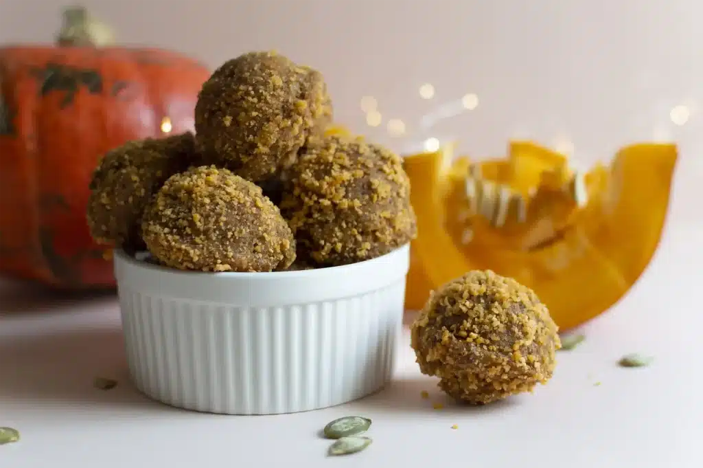 A batch of No-Bake Pumpkin Protein Bites on a rustic table, symbolizing healthy fall snacking.